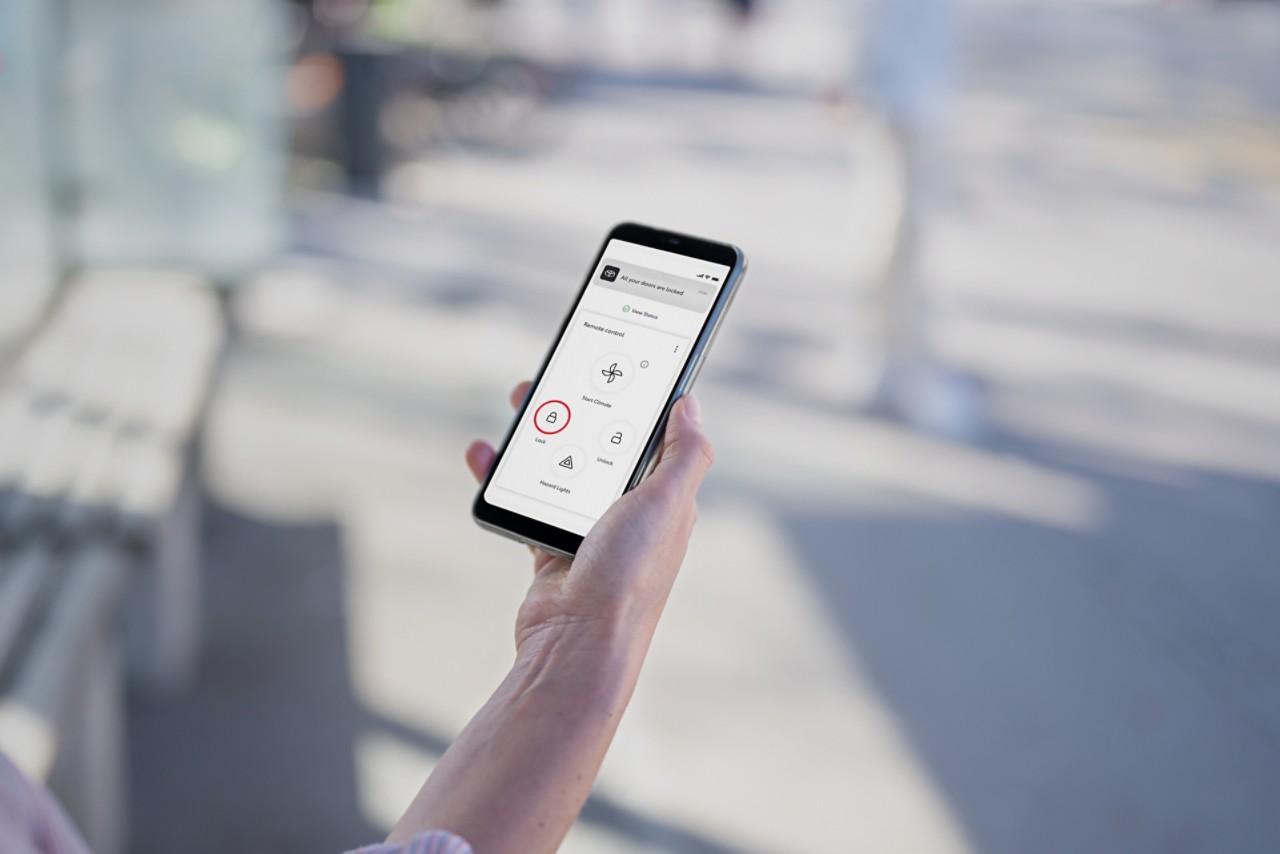 En person håller i en mobiltelefon som visar försäkringsalternativ i MyToyota-appen.