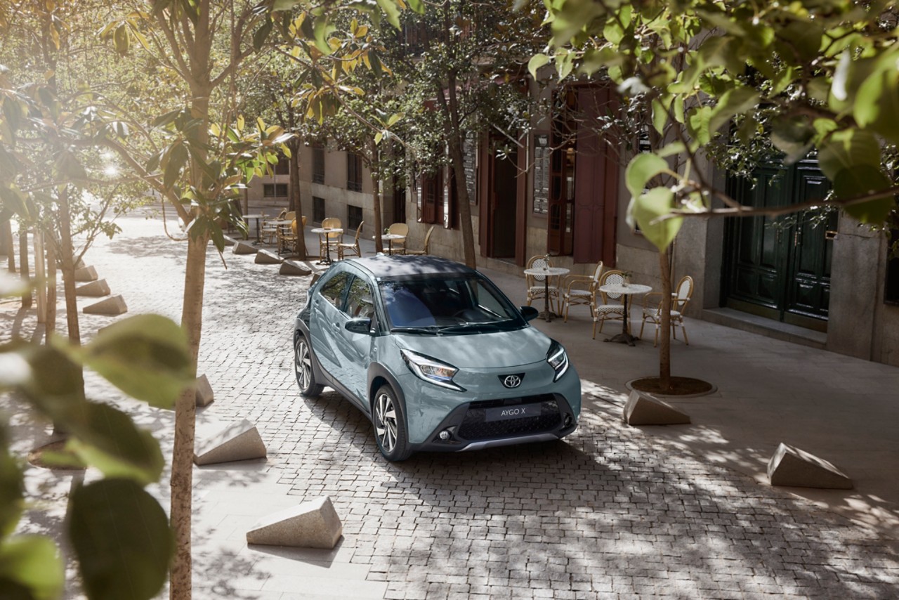 Birds eye view of Tarragon Green Aygo X driving in the city