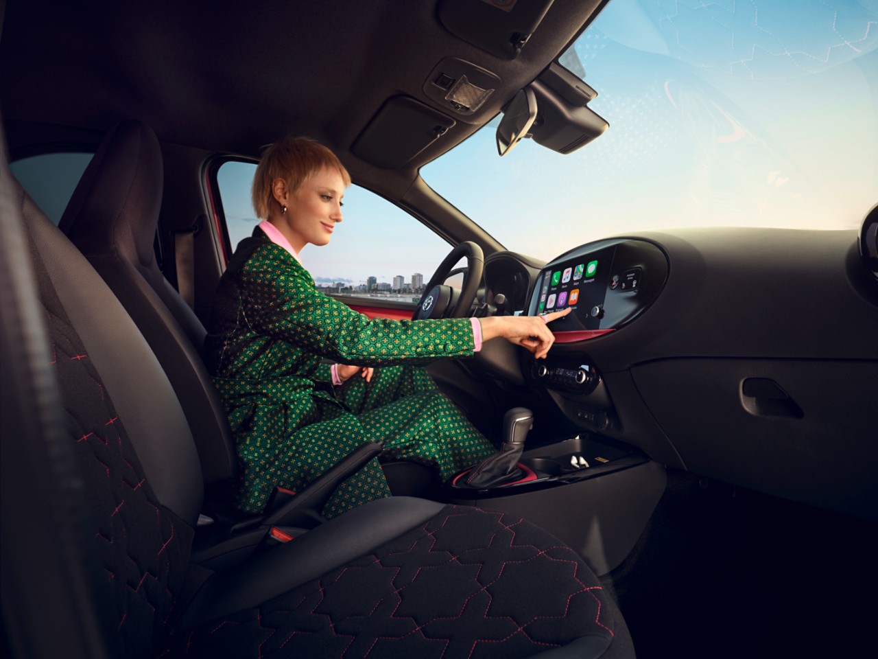 Image showing the dashboard and steering wheel of Chili Red Aygo X on a sunny day